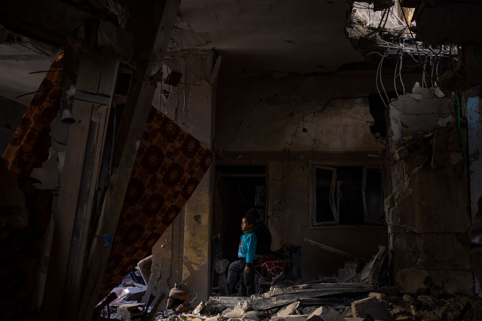A Palestinian child looks at damage to his family's house after an Israeli strike in Rafah, Gaza, on Thursday, February 8. Israel has been bombarding Rafah with airstrikes and shelling for weeks as it continues its war against the Hamas militant group that attacked the country in October.