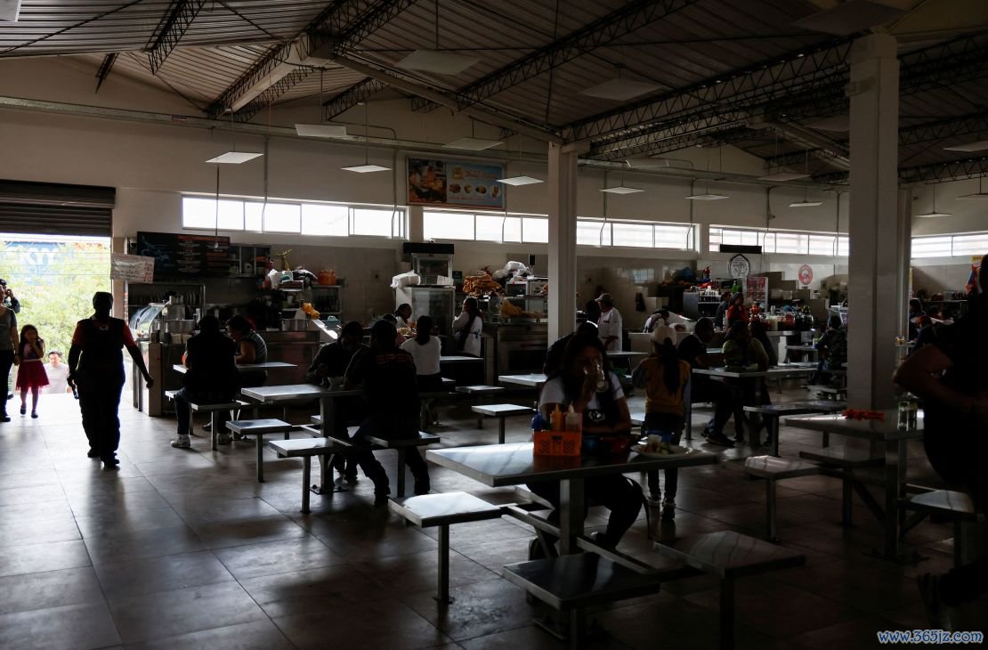 Customers eat in a darkened market square during a power cut in Quito, Ecuador, on April 18.